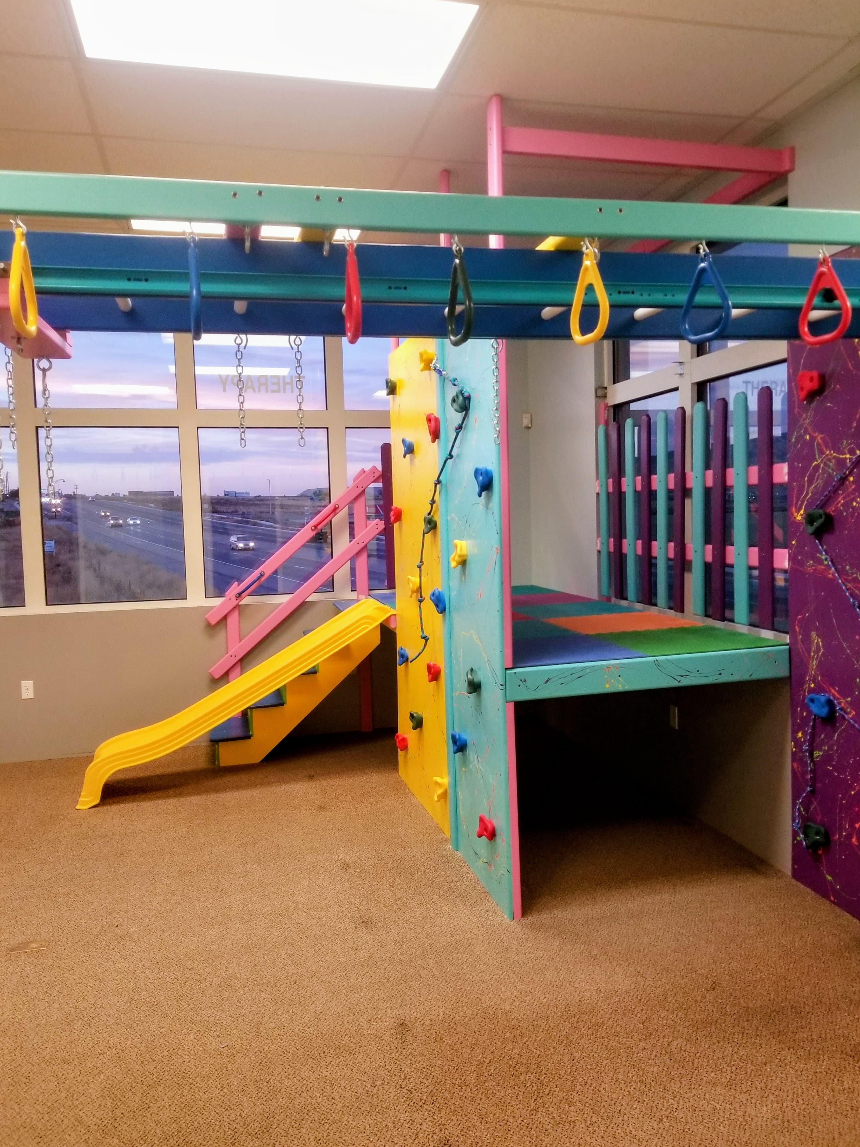 Clinic sensory gym with rock wall and swings